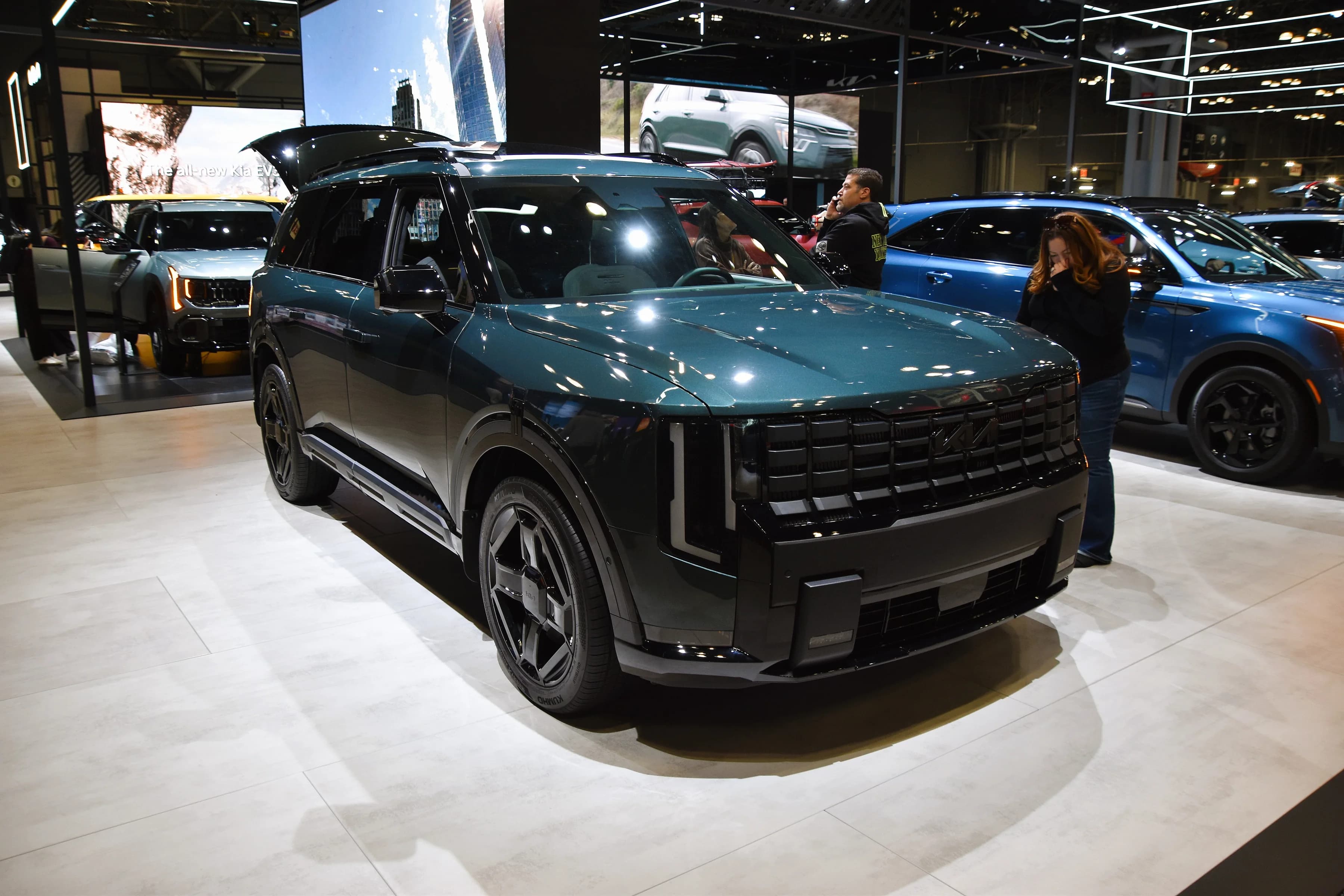 A dark green second-generation Kia Telluride X-Line on an auto show stand