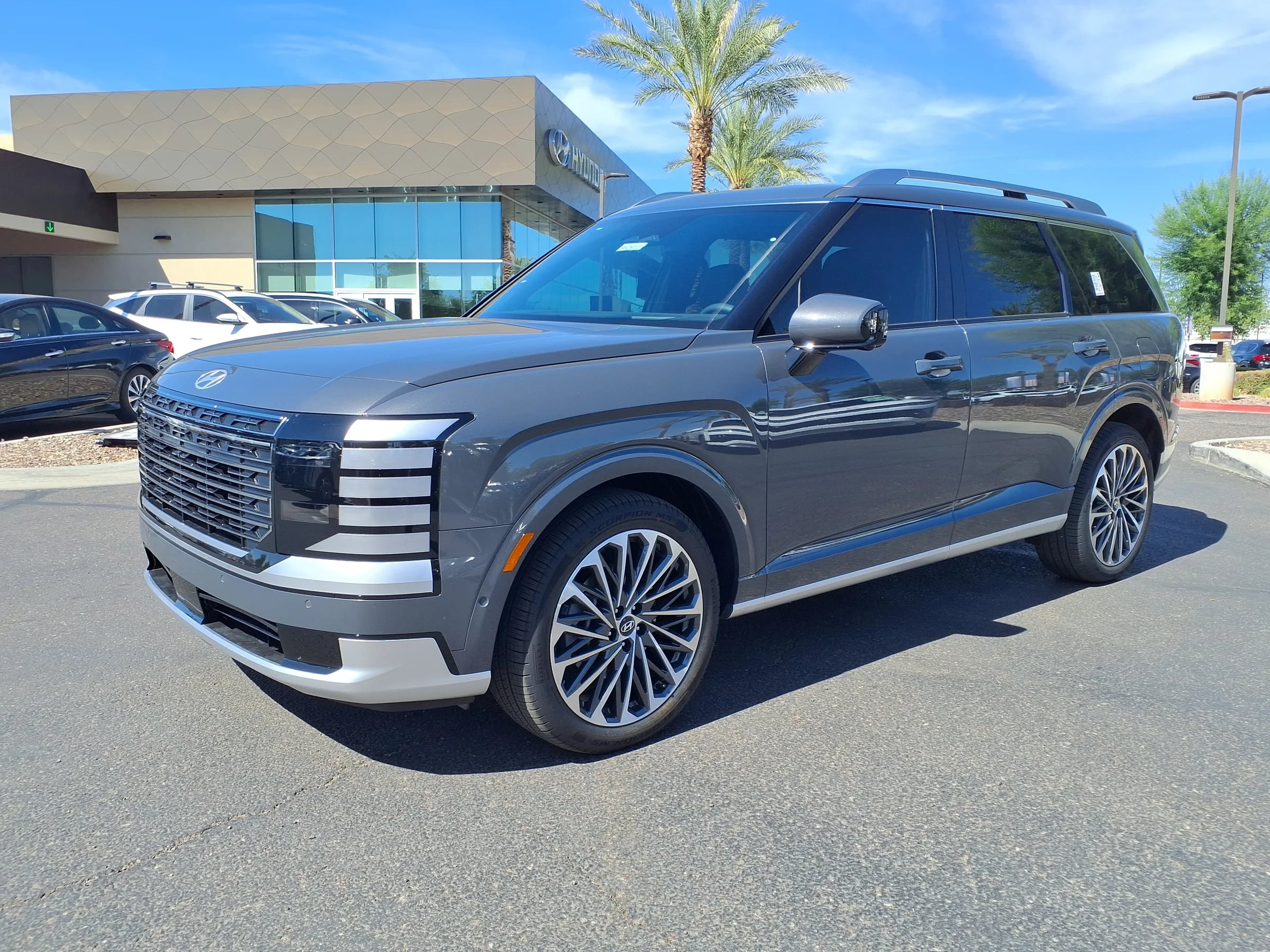 A grey 2026 Hyundai Palisade Calligraphy, front three-quarter, on a sunny dealer lot
